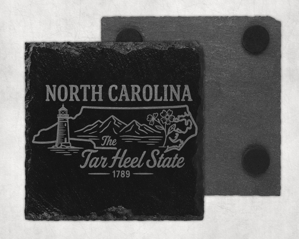 Black slate coaster with North Carolina design, lighthouse, mountains, and flowers.