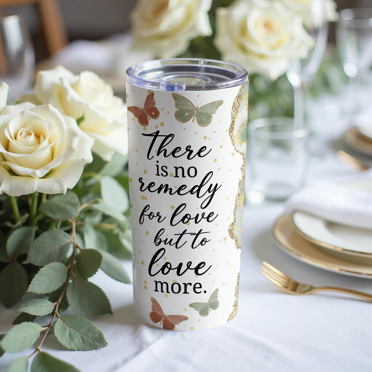 White tumbler with butterflies and text "There is no remedy for love but to love more."