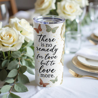White tumbler with butterflies and text "There is no remedy for love but to love more."
