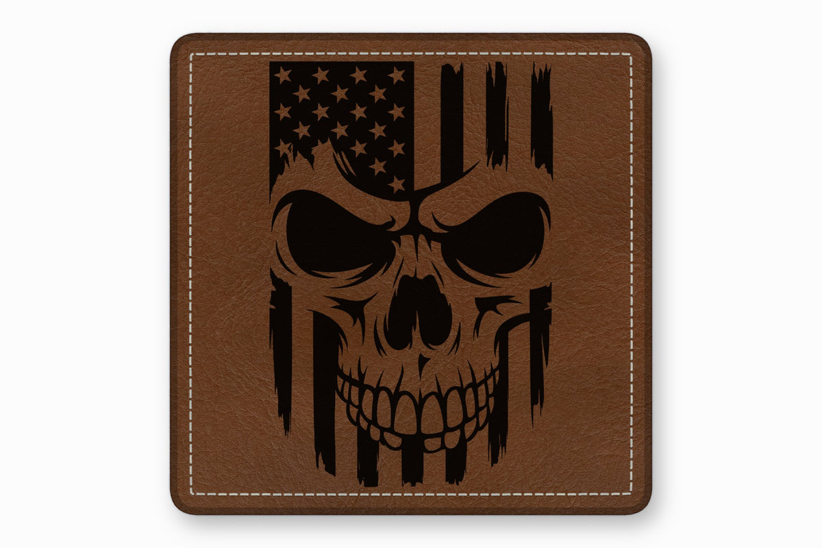 Brown square leather patch with white stitched borders and a black engraved American flag skull design.