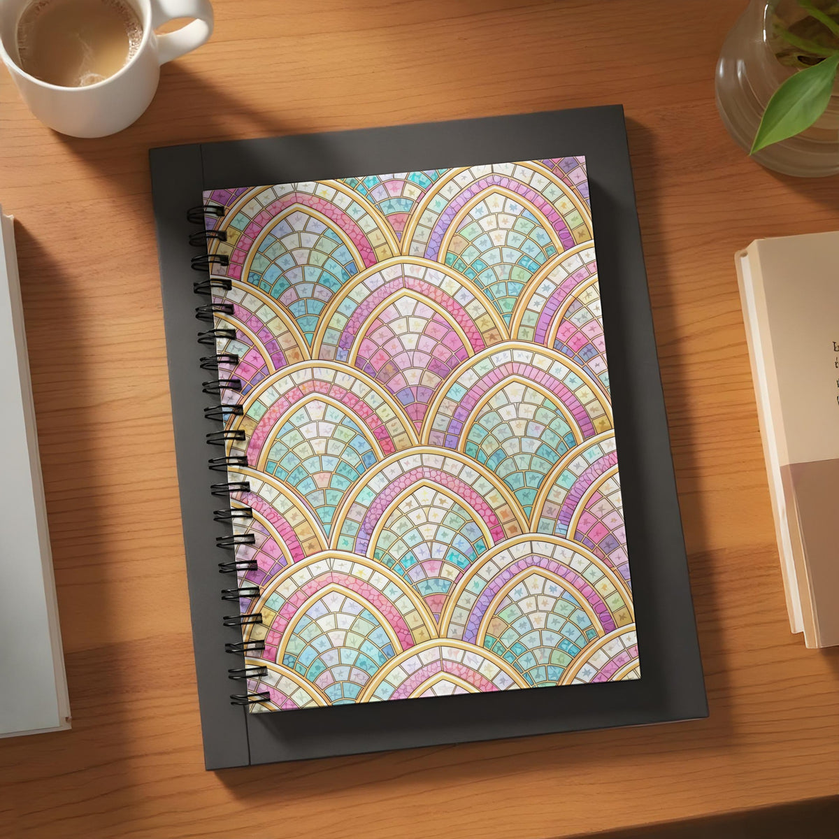 Spiral bound notebook with a repeating art deco fan pattern in pastel colors.
