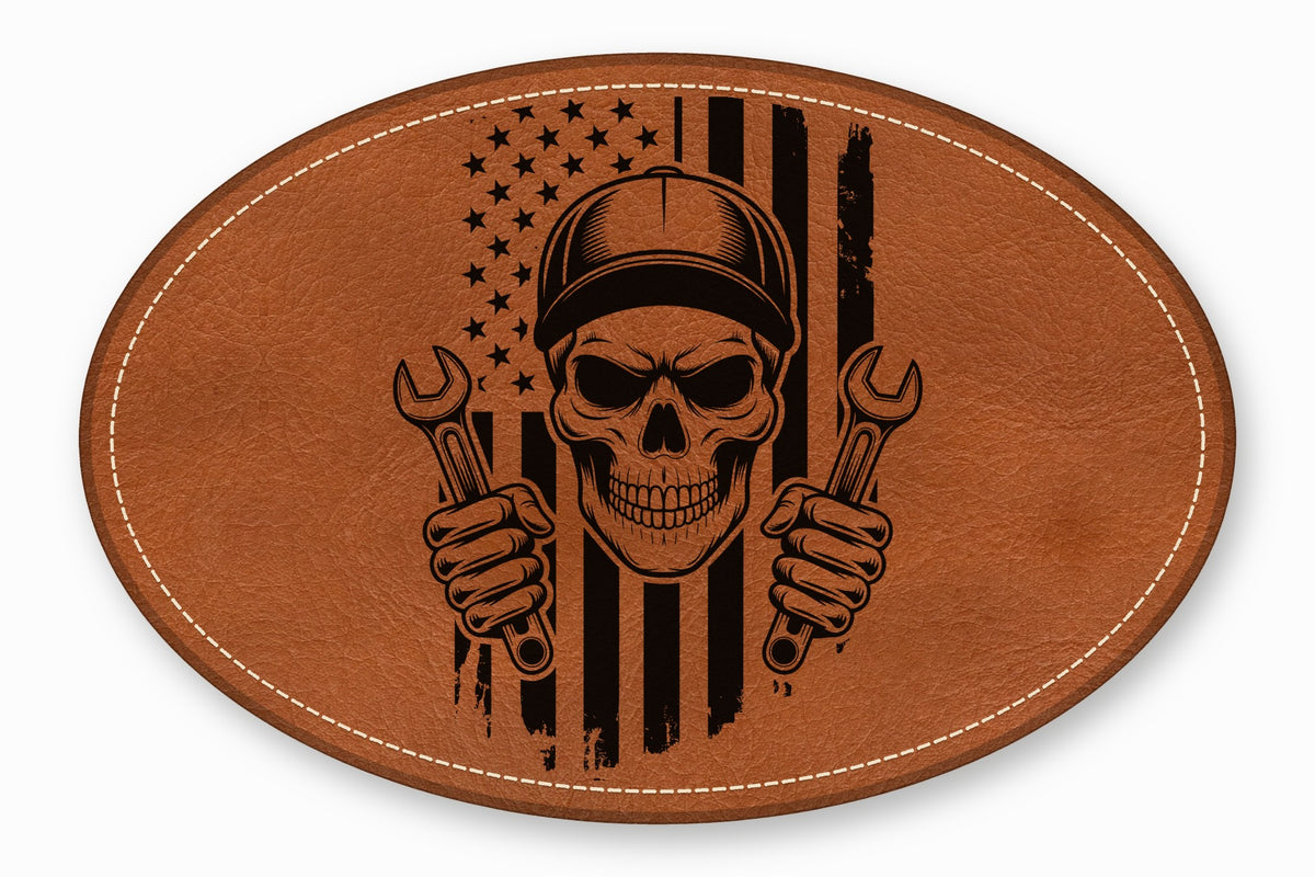 An oval brown leather patch featuring an American flag and mechanic skull graphic with wrenches.