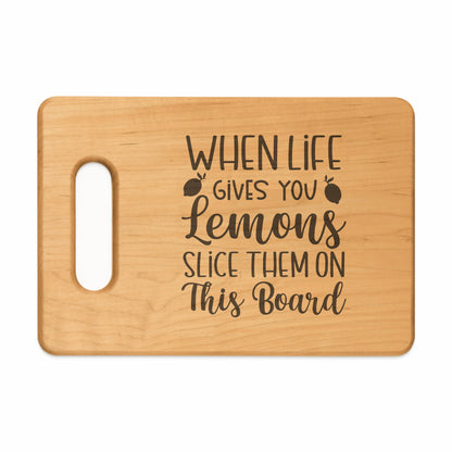 Wooden cutting board with text "When life gives you lemons slice them on this board".