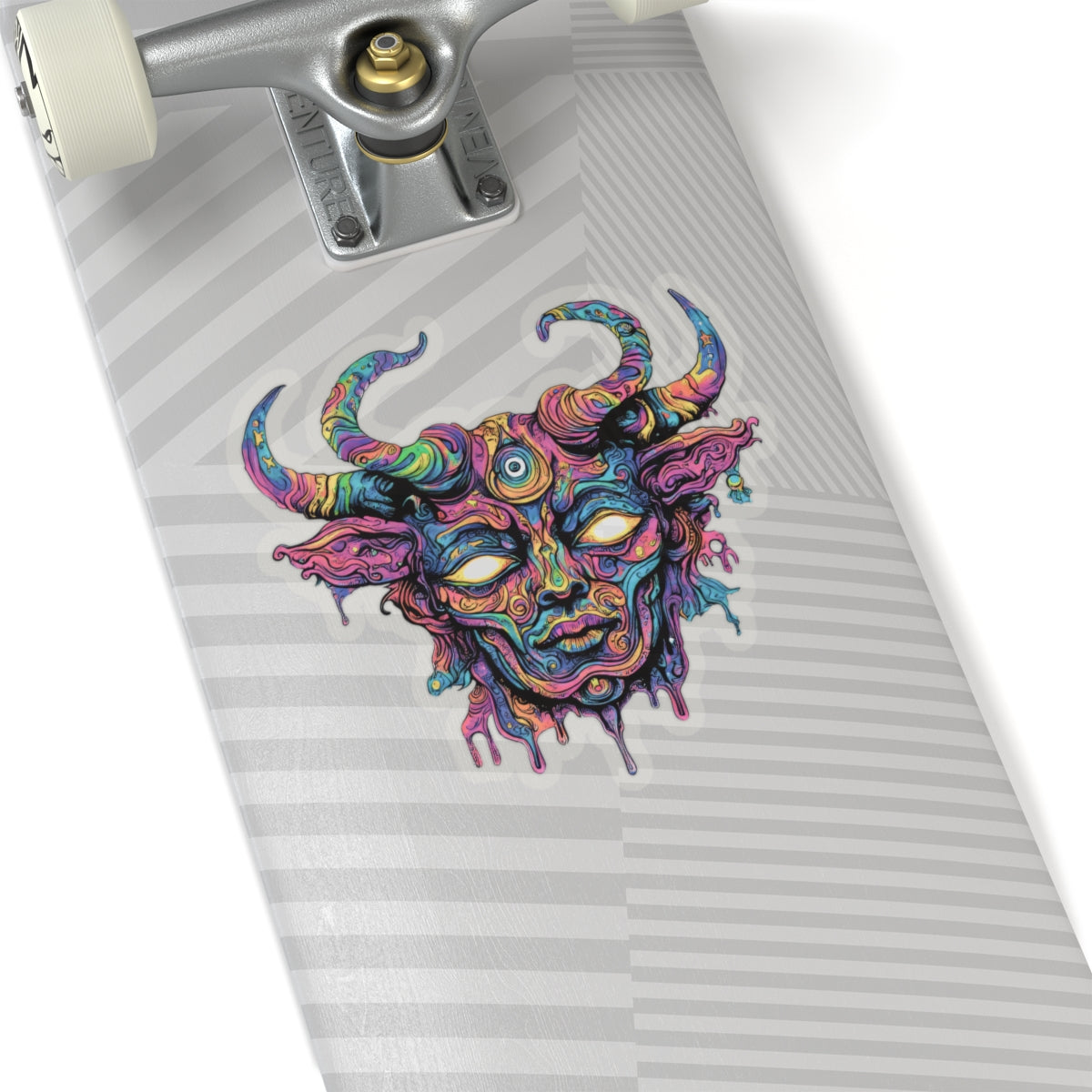 Colorful abstract bull's head sticker on a skateboard deck with silver trucks.