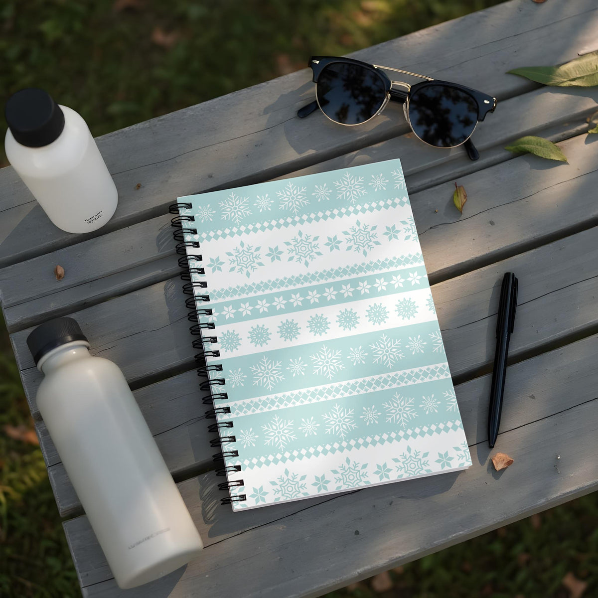Spiral notebook with light blue and white snowflake pattern.