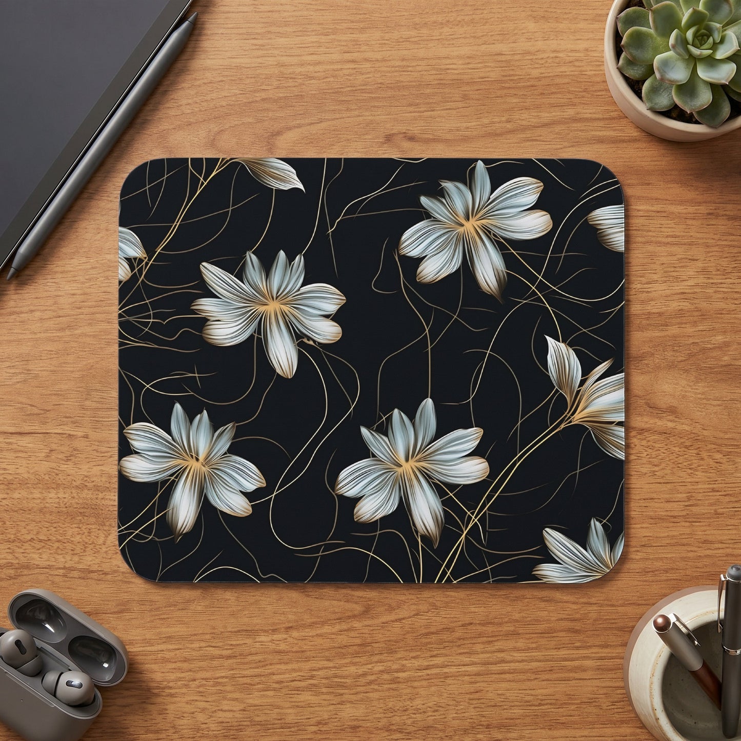 Mousepad with a dark floral pattern and golden accents on a wooden desk.