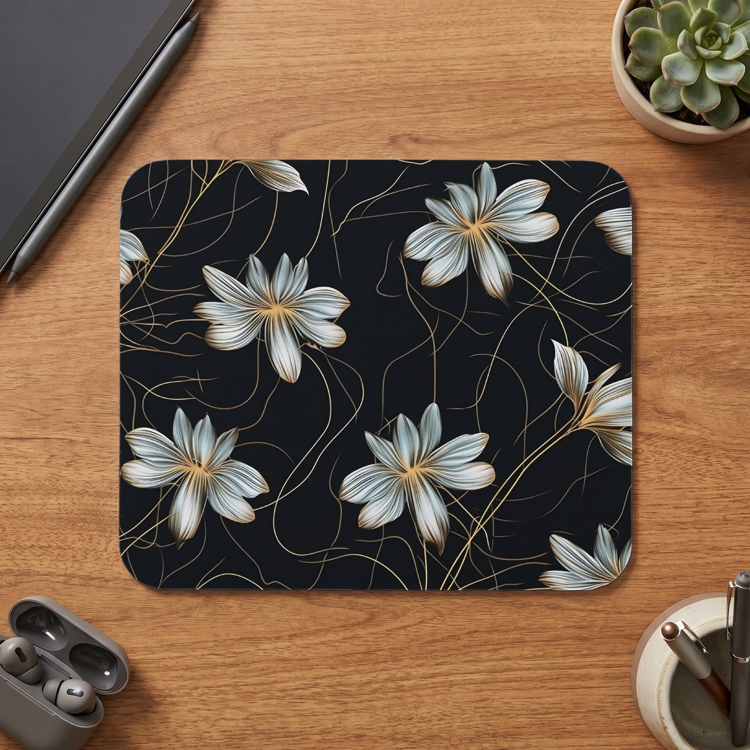 Mousepad with a dark floral pattern and golden accents on a wooden desk.