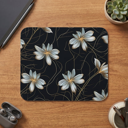 Mousepad with a dark floral pattern and golden accents on a wooden desk.