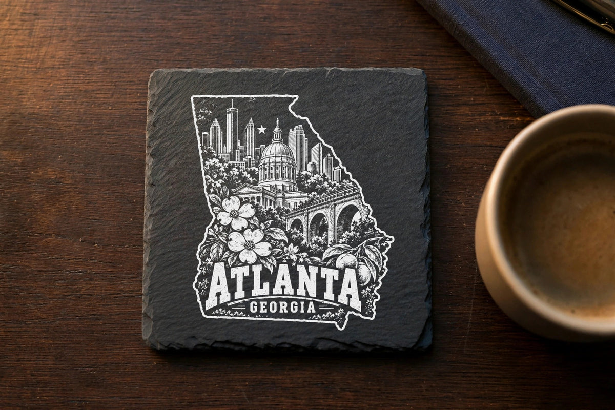 Black square slate coaster featuring a white engraved map of Georgia filled with Atlanta landmarks and the text Atlanta Georgia.