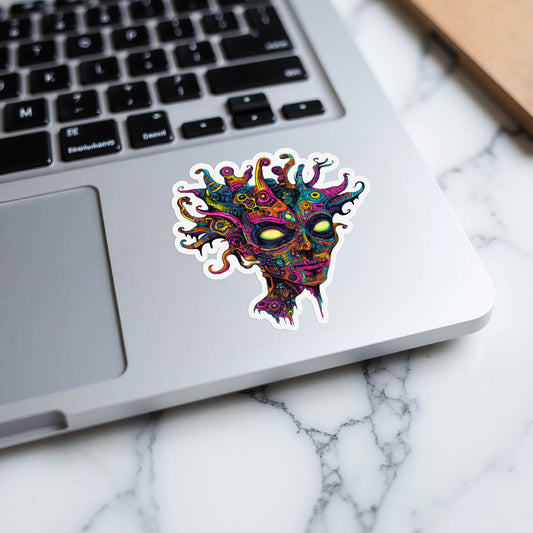 Colorful abstract face sticker with yellow eyes on a laptop keyboard.
