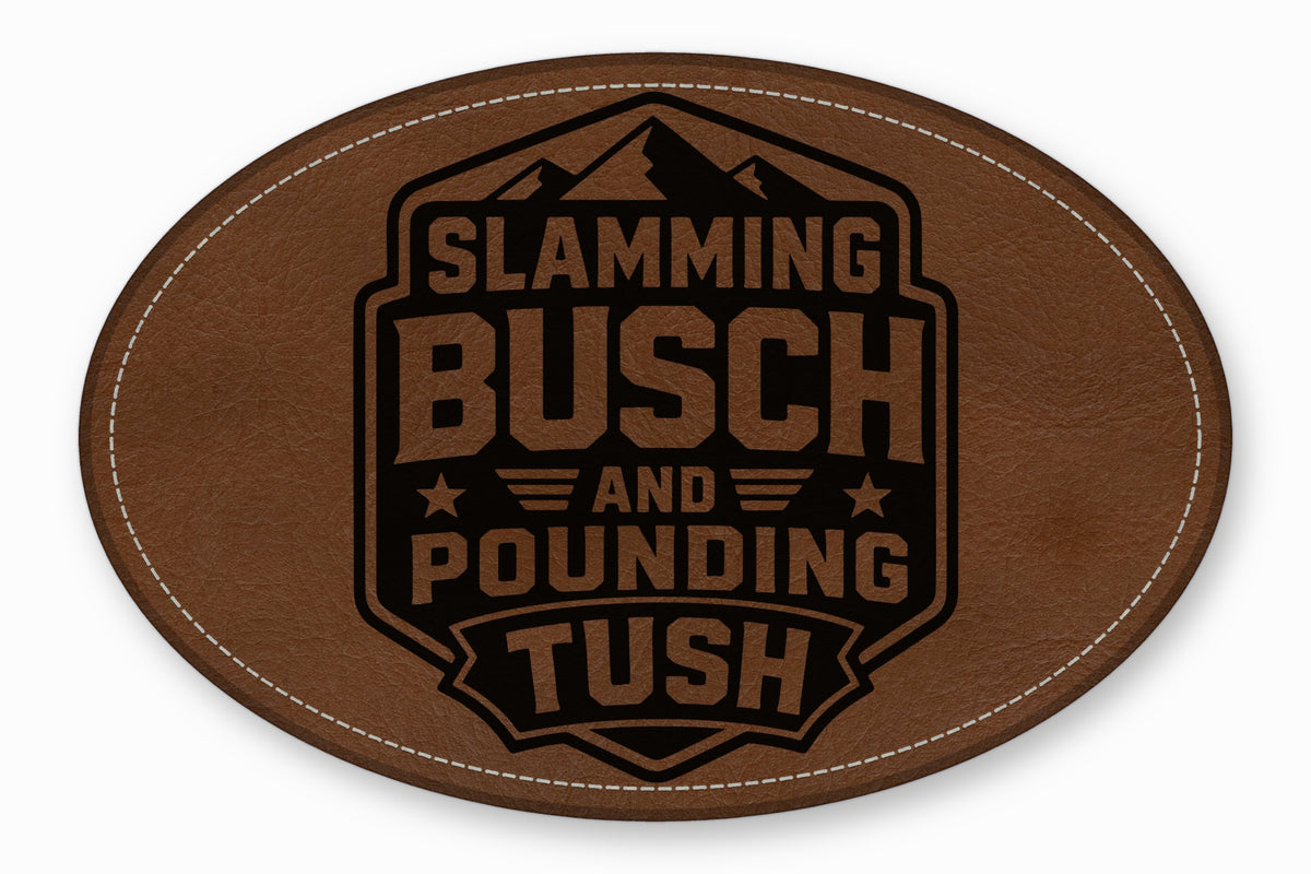 Brown oval faux leather patch with white stitched border and black stamped text reading SLAMMING BUSCH AND POUNDING TUSH.