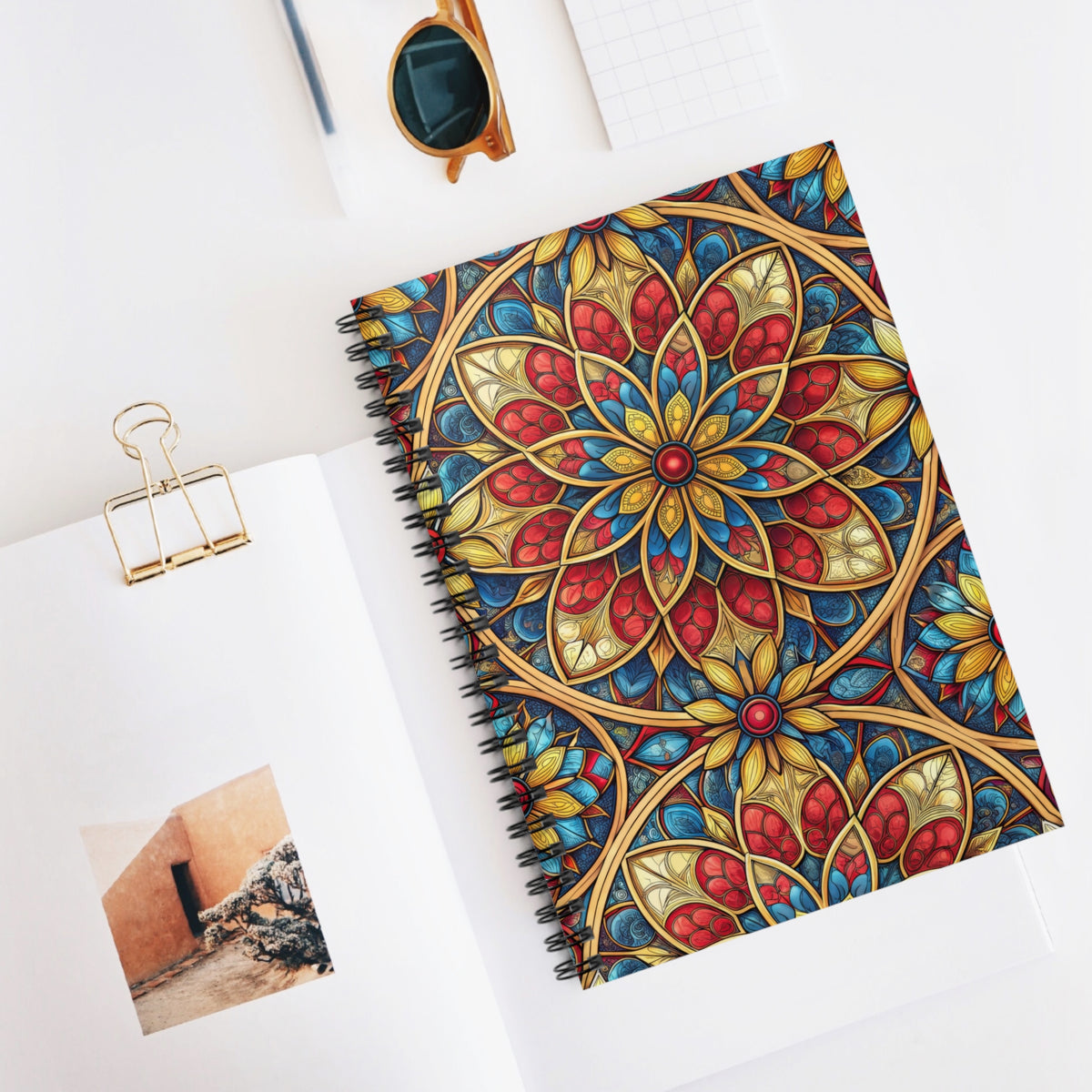 Spiral-bound notebook with colorful stained-glass mandala pattern cover.