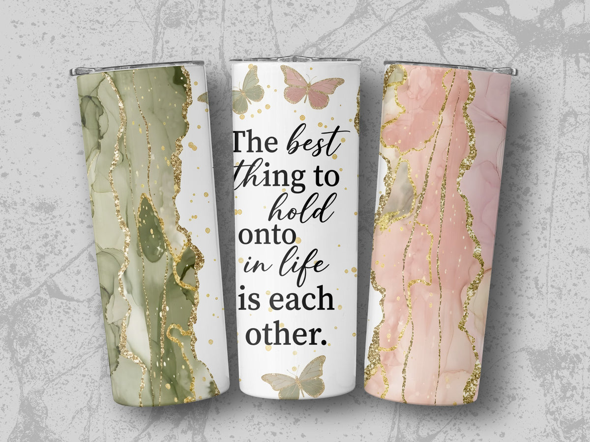 Three tumblers with abstract marble and gold designs, one with text.