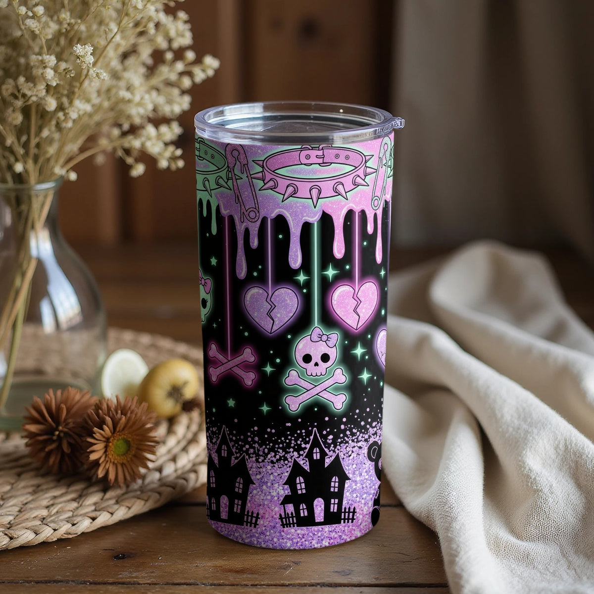 Tumbler with dripping pastel elements, skulls, hearts, and haunted houses.