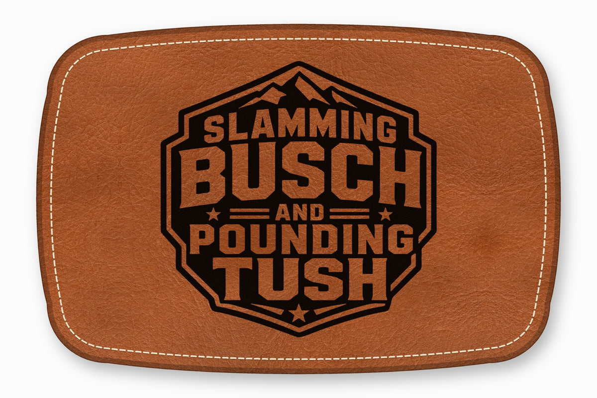 Brown leather patch with white stitching and a black engraved text design that reads Slamming Busch And Pounding Tush.