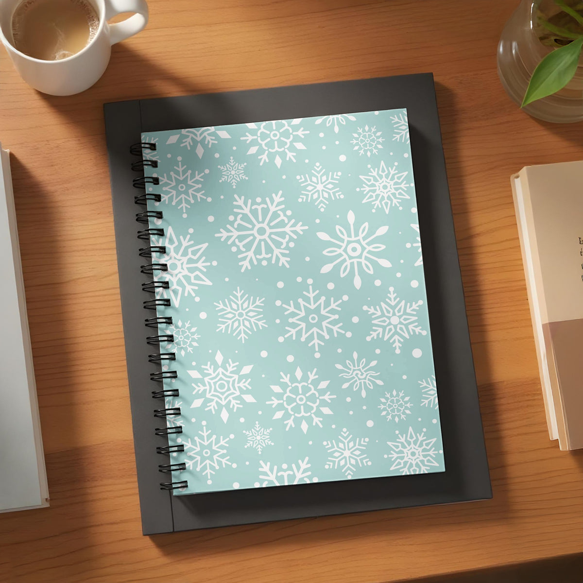 Spiral notebook with a white snowflake pattern on a light blue background.