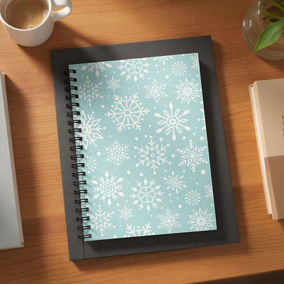 Spiral notebook with a white snowflake pattern on a light blue background.