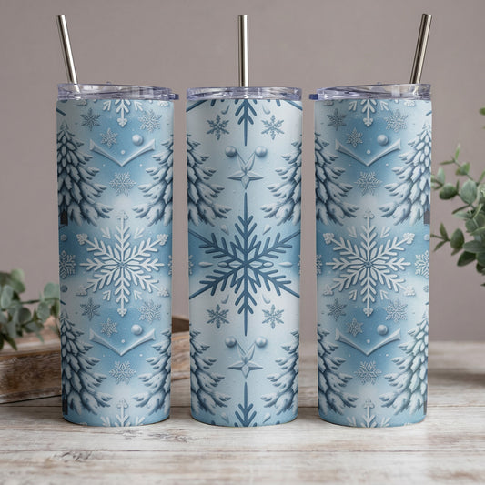 Three snow-covered trees and snowflakes pattern on blue tumblers with metal straws.