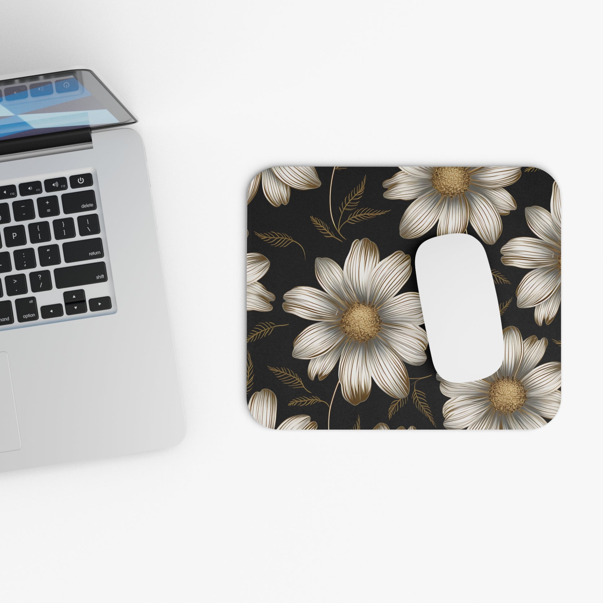 Mousepad with white and gold flowers on a dark background.