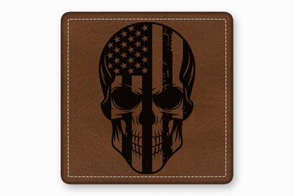 A square brown leather patch with white stitched borders features a black engraved American flag skull design.