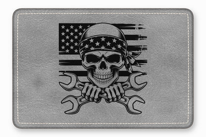 Grey leather rectangular patch with a black graphic of a skull wearing a star bandana and crossed wrenches against a distressed American flag.