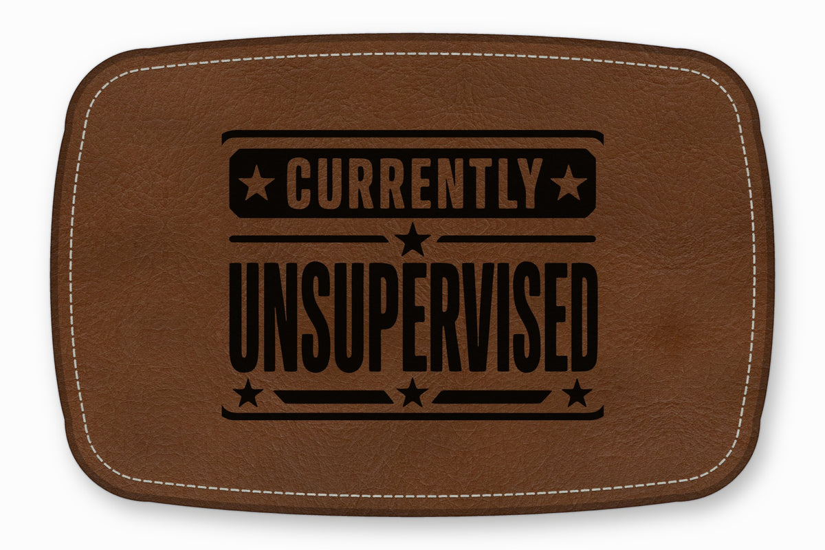 Brown leather patch with white stitching and the black text Currently Unsupervised.