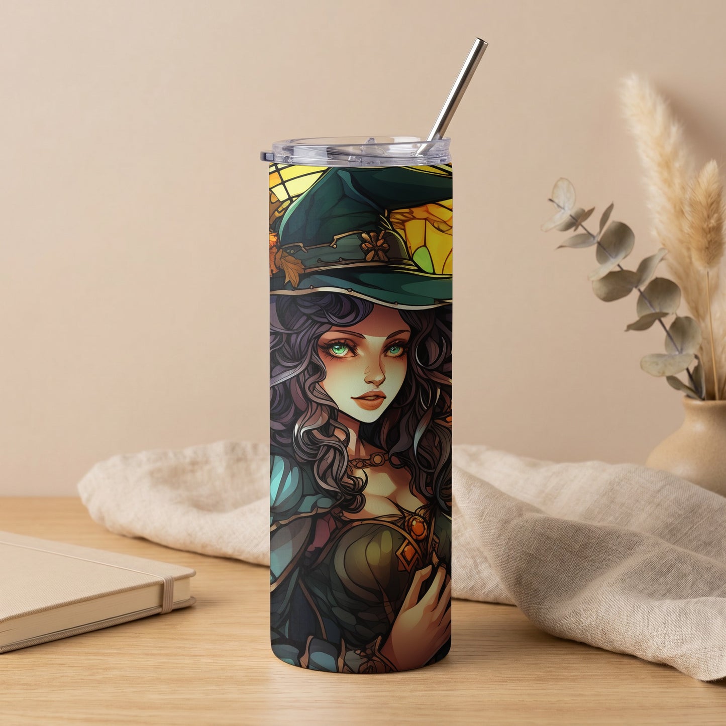 Tall tumbler with a witch illustration, green hat, and metallic straw.