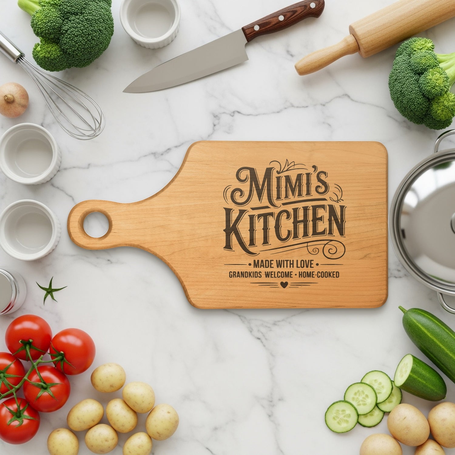Wooden cutting board with "Mimi's Kitchen" engraving surrounded by fresh ingredients.
