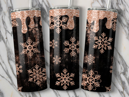 Three tumblers with a rose gold glitter drip and snowflake design on a black textured background.