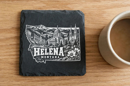 Square black slate coaster on a wooden surface with a white engraved map of Helena, Montana.