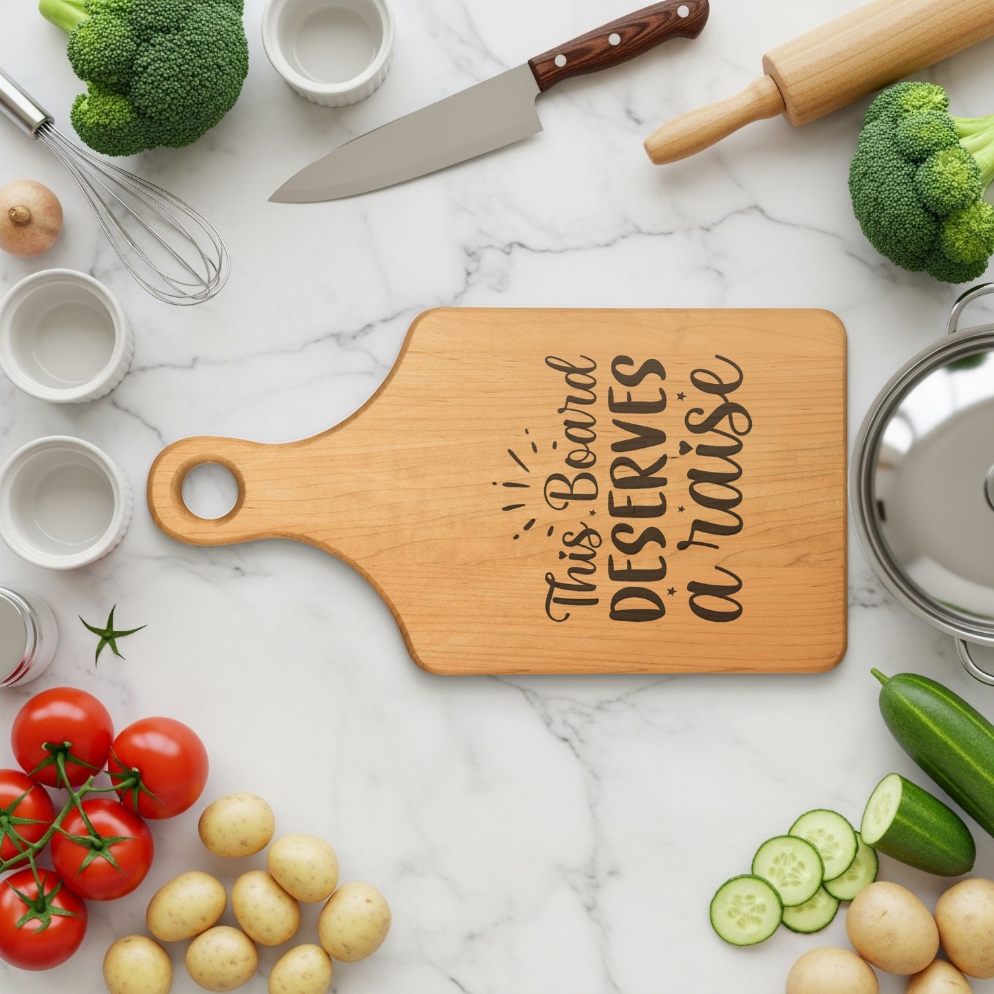 Wooden cutting board with engraved text "This Board DESERVES a raise".