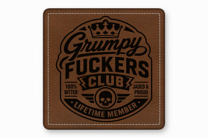 Brown square leather patch featuring a black embossed design with a skull, crown, and text reading Grumpy Fuckers Club.