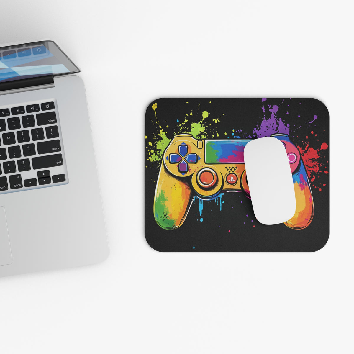 Colorful video game controller graphic on a black mousepad with paint splatters.