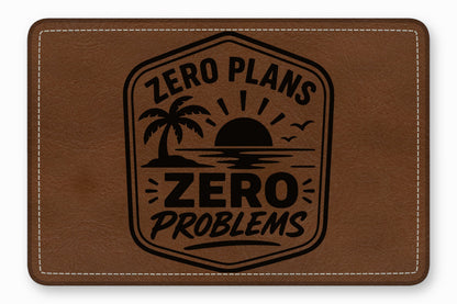 A brown leather patch with white stitched edges featuring an engraved tropical sunset and text reading Zero Plans Zero Problems.