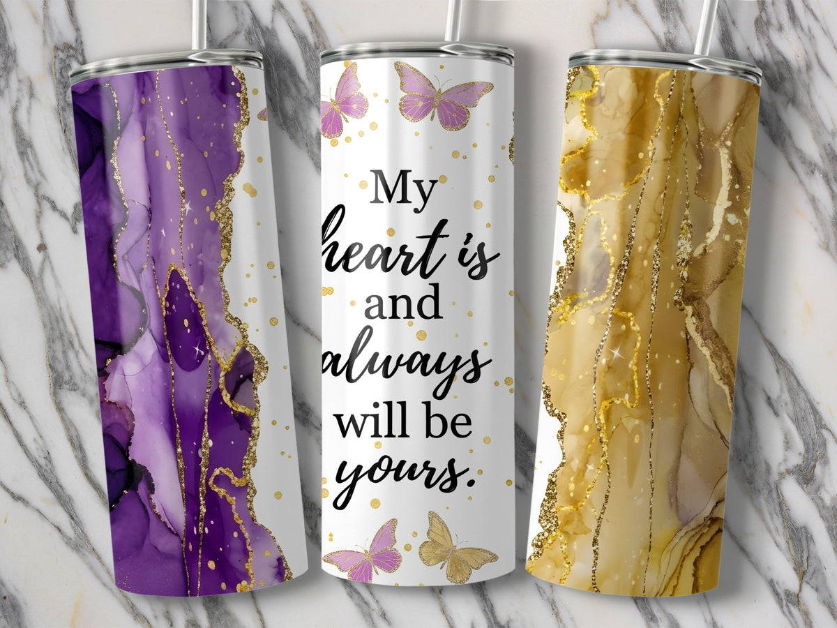 Three tumblers: purple marble, white with butterflies and text, gold marble.
