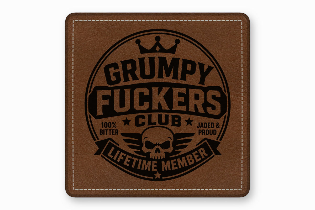 Brown leather patch with white stitched border and black debossed text reading Grumpy Fuckers Club.