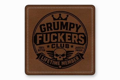 Brown leather patch with white stitched border and black debossed text reading Grumpy Fuckers Club.