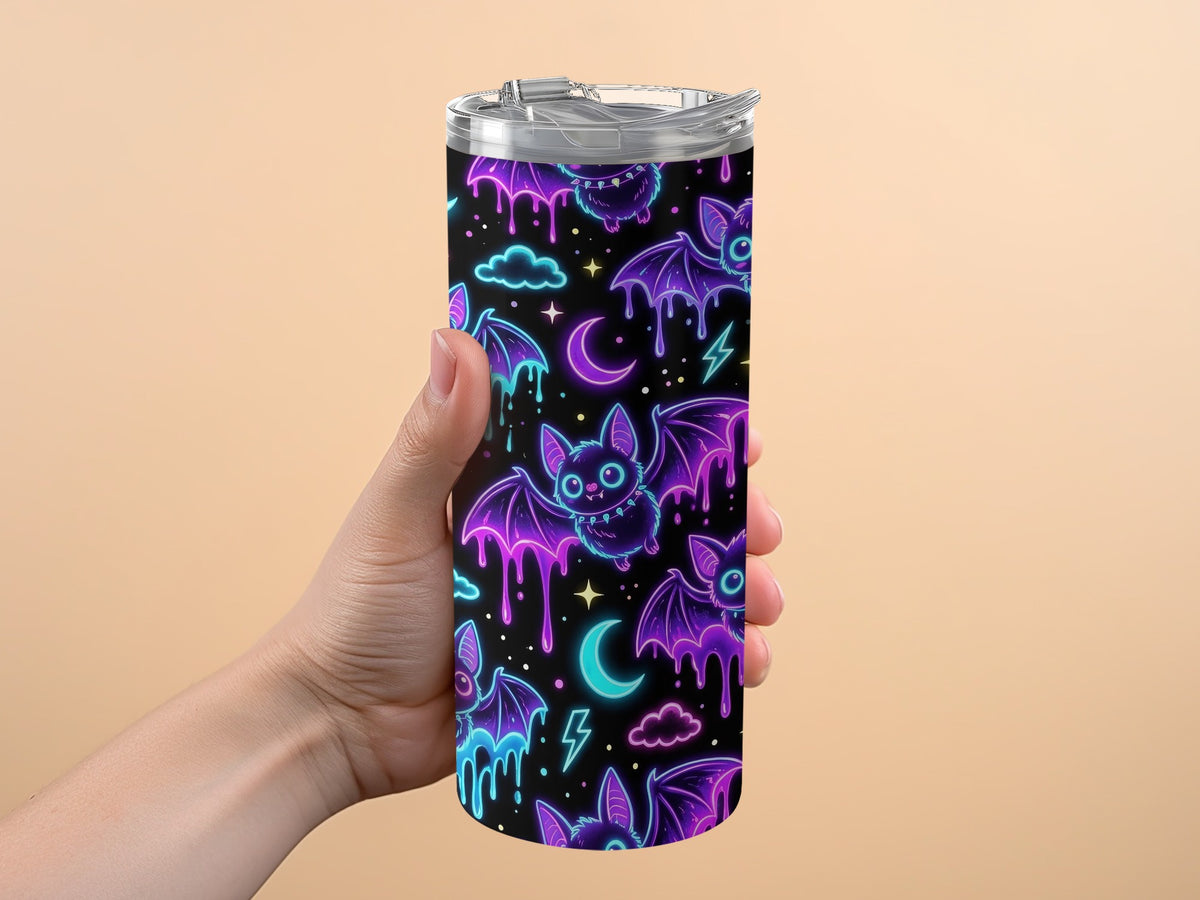 Tumbler with neon purple and blue bats, moons, clouds, and lightning bolts.
