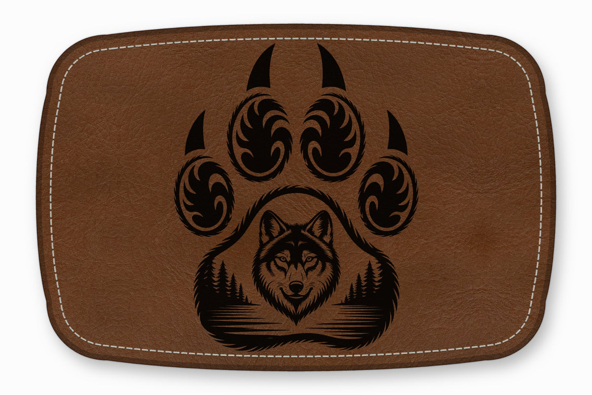 A brown leather patch features a black graphic of a bear paw containing a wolf and forest landscape.