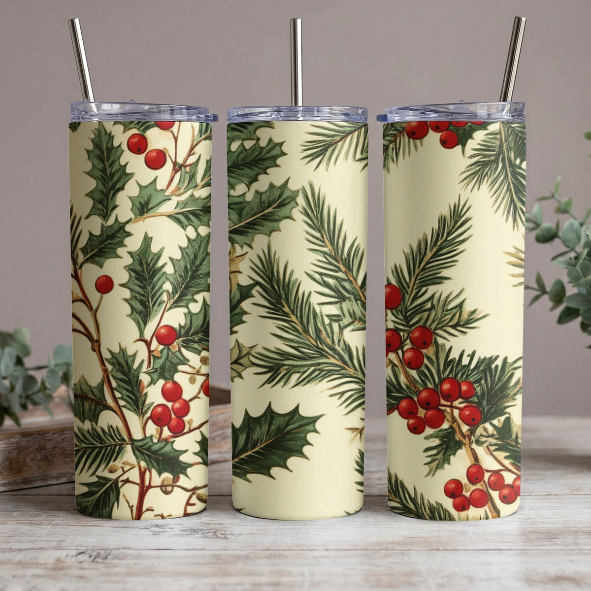 Three tumblers with a repeating pattern of holly leaves and red berries on a cream background.
