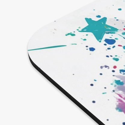 Mousepad with teal star and colorful paint splatters on white surface.