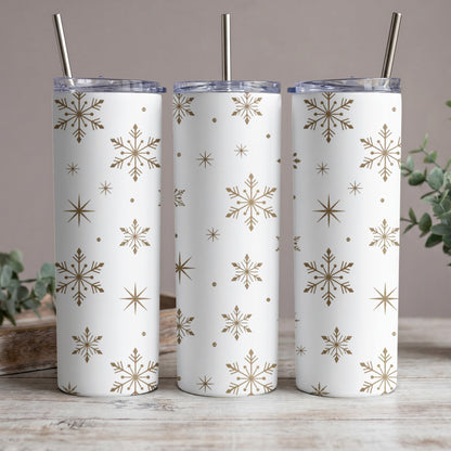 Three white tumblers with a gold snowflake pattern and silver straws.