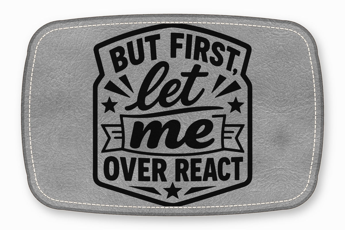 Gray faux leather patch featuring the black engraved text "BUT FIRST, let me OVER REACT".