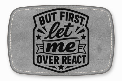 Gray faux leather patch featuring the black engraved text "BUT FIRST, let me OVER REACT".
