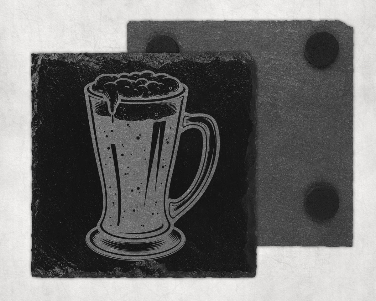 Engraved beer mug on a dark slate coaster with another coaster behind it.