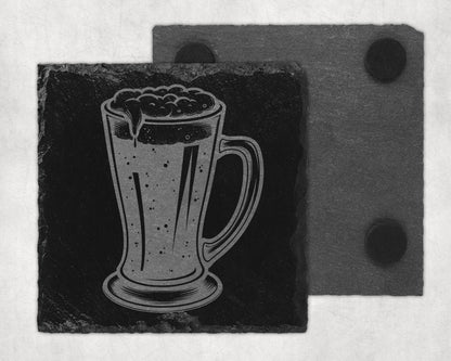 Engraved beer mug on a dark slate coaster with another coaster behind it.