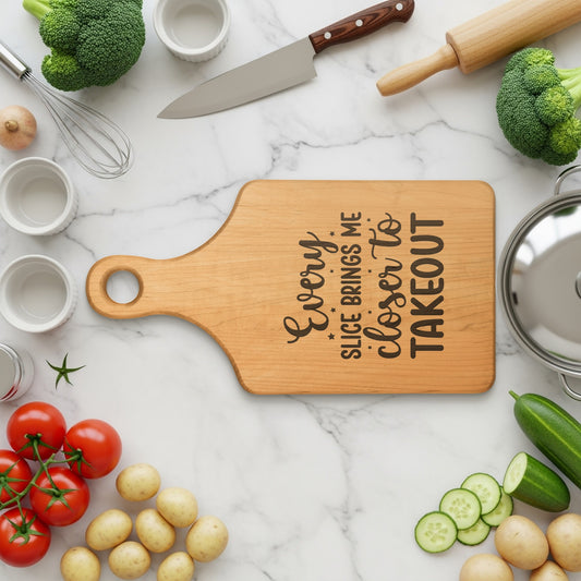 Wooden cutting board with "Every slice brings me closer to takeout" engraved text.