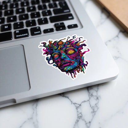 Psychedelic melting face sticker on a laptop keyboard.
