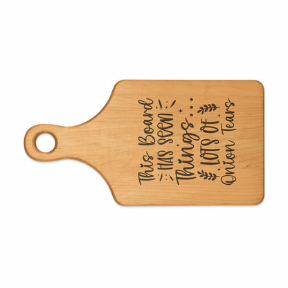 Wooden cutting board with engraved text: "This Board Has Seen Lots of Onion Tears."