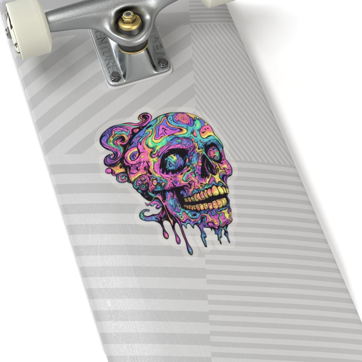 Colorful melting skull sticker on a skateboard deck with silver trucks.